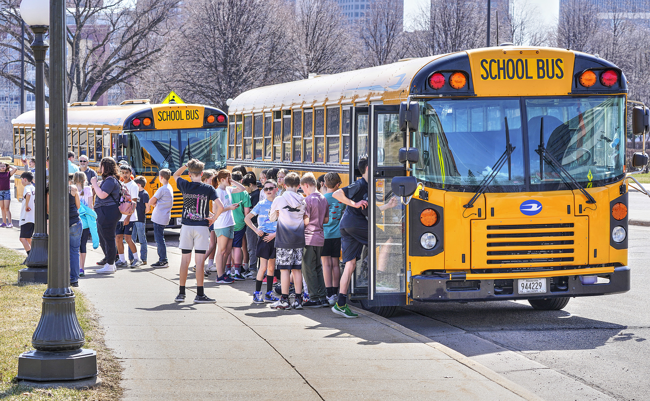 Students board buses near the Capitol. A House bill would allow Minnesota districts to start school earlier than usual in 2026 and 2027 due to late Labor Days. (House Photography file photo)